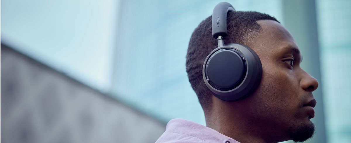 En mann som lytter til musikk med Philips X3-hodetelefoner
